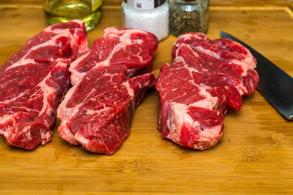 Three Chuck Steaks on Cutting Board — Stock Photo, Image