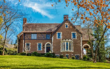 Yeşil çimenlerin üzerinde klasik windows ile eski tuğla ev