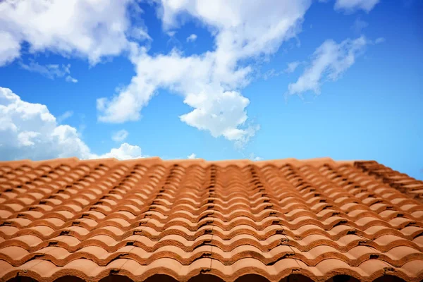 Dak van rode klei tegels onder wolkenluchten — Stockfoto