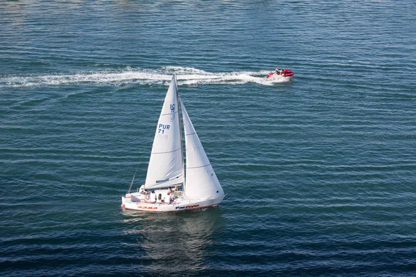Jetski passerende zeilboot — Stockfoto