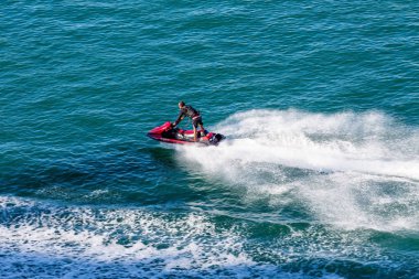 Adam kırmızı Jet Ski üzerinde ayakta
