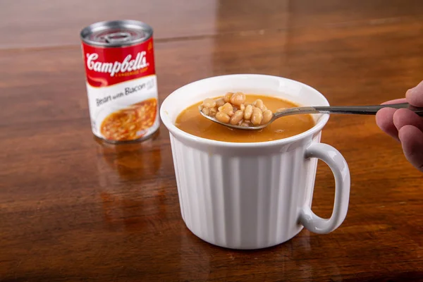 豆とベーコンのスープのスプーンを保持 — ストック写真