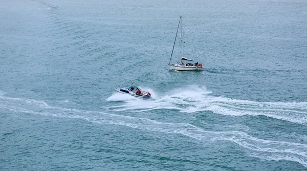 Plachetnice a motorový člun v zelené vodě — Stock fotografie