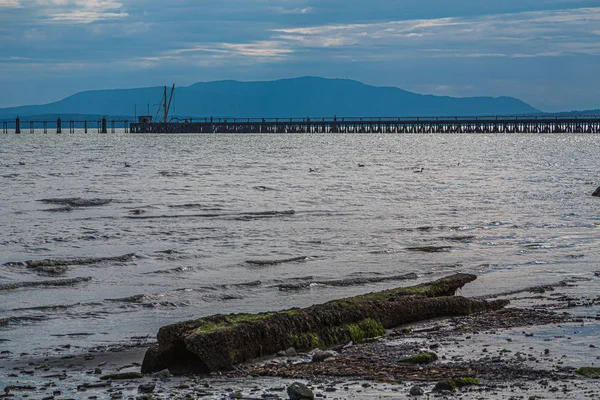 Bay and Pier Beyond Rocky Beach — Stock Photo, Image