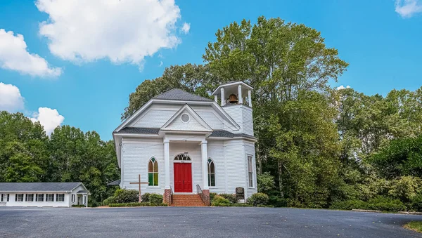 Liten vit kyrka med röd dörr — Stockfoto