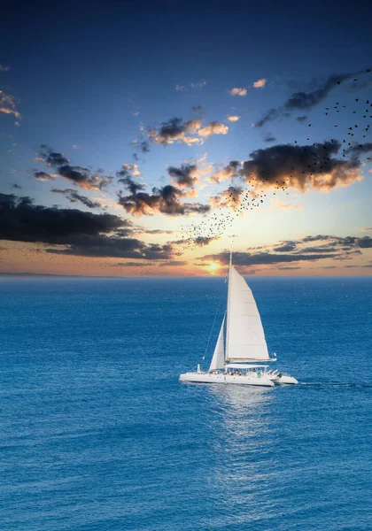 Белая лодка на закатном небе — стоковое фото