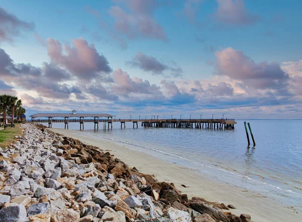 Menschen auf der Seebrücke jenseits der Felswand — Stockfoto