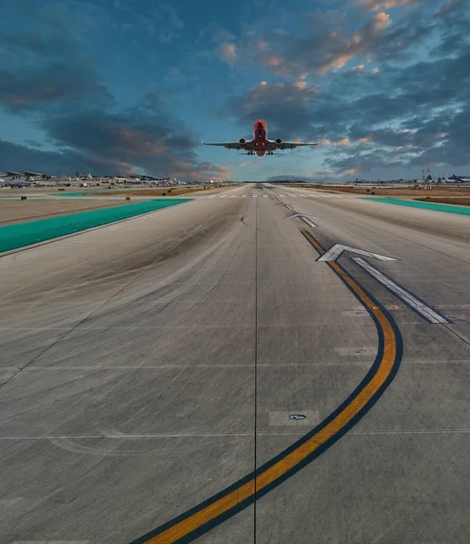 Vliegtuig landing op baan bij zonsondergang — Stockfoto