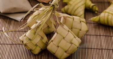 Ketupat (pirinç hamur tatlısı) Güney Doğu Asya'da festival sezonunda yerel bir incelik var. Ketupat, küçük Hindistan cevizi yapılan bir doğal pirinç kaplama pirinç geleneksel mat zemin üzerine yemek pişirmek için bırakır. 4 k görüntüleri video.