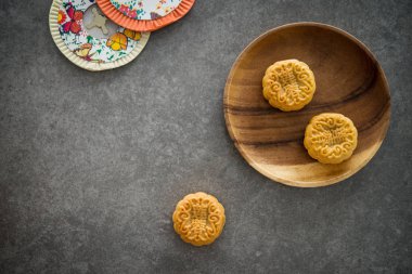Arkadaşlarınız veya aileniz için geleneksel pişmiş moon kek sonbahar ortası festivali sırasında sunulmaktadır. Flatlay tablo üstten görünüm koyu arka plan kopya alanı ile. Yapıştırırken mooncake temsil