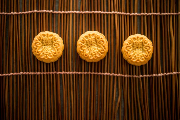 Traditional pastry mooncakes is eaten during the Mid-Autumn Festival. Flatlay on table, top down view low light with copy space. The Chinese character on the moon cake represent \