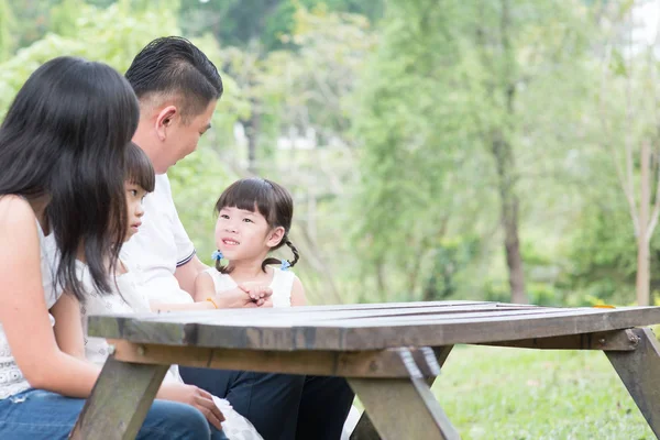 屋外の公園で自然を楽しんでいるアジア系の家族 木製のテーブルに空の空間 — ストック写真