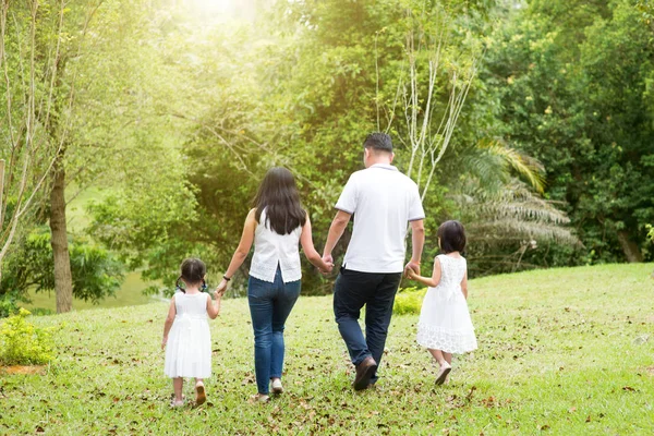 亚洲家庭户外 父母和孩子牵着手走在绿色公园 后视图 — 图库照片