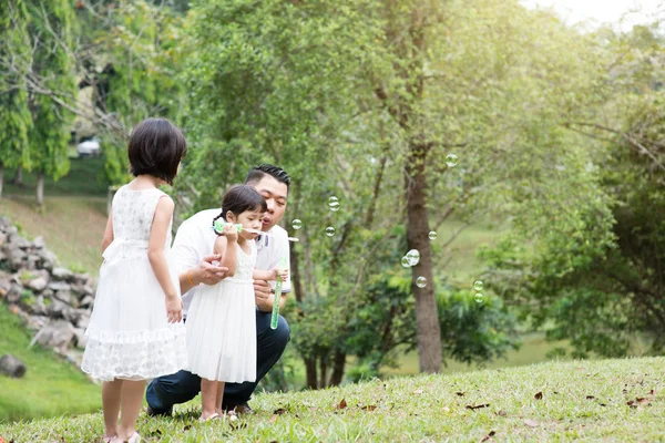 父母和孩子们在花园公园吹肥皂泡 亚洲家庭户外活动 — 图库照片