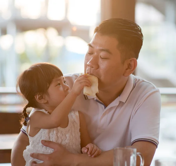 孩子在自助餐厅给爸爸喂面包 亚洲家庭户外生活方式与自然光 — 图库照片