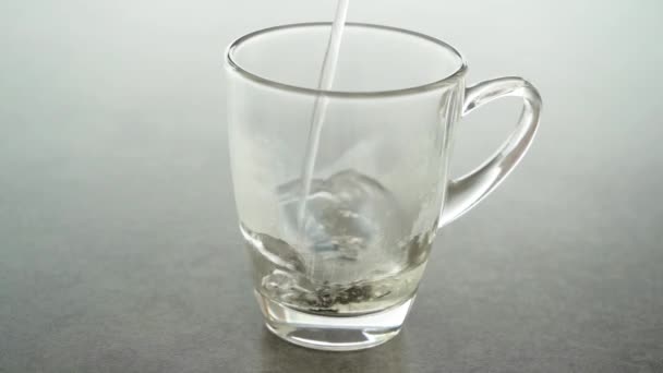 扔一个茶叶立方体和倒入热水到玻璃 慢动作素材视频 — 图库视频影像