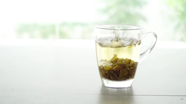 Ice Cube Adding Jasmine Tea Glass Slow Motion Footage Video — Stock Video