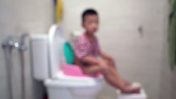 Cinco Años Edad Niño Asiático Sentado Taza Del Inodoro Deliberadamente — Vídeo de stock