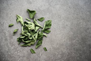 Koyu arka planda kurutulmuş köri yaprakları. Kopyalama alanı olan üst görünüm.