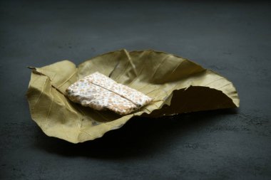 Taze tempeh koyu arka planda yaprağa sarılmış, vejetaryen yiyecekler, Endonezya soya fasulyesi ürünleri..
