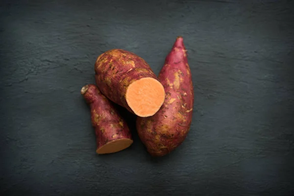 Las Batatas Naranja Crudas Cierran Sobre Fondo Oscuro Vista Superior —  Fotos de Stock