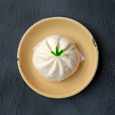 Baozi ya da Bao Dim Sum tabakta koyu arkaplanda yatıyordu..