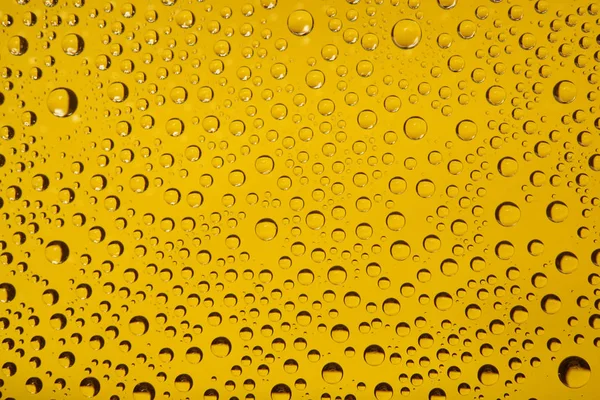 Waterdruppels Een Gele Achtergrond — Stockfoto