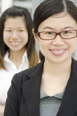 Asian business team, two businesswomen, focus foreground.