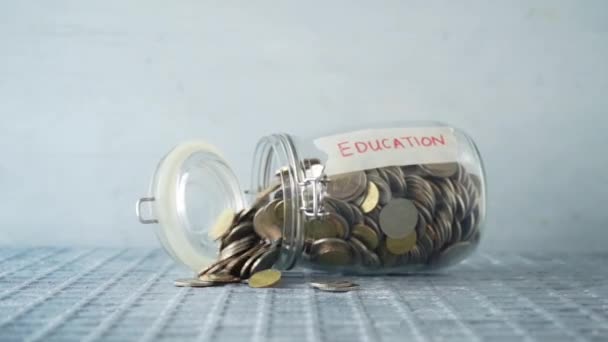 Slow Motion Munten Geld Gedaald Van Glazen Pot Met Onderwijs — Stockvideo