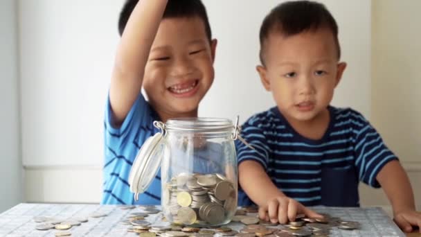 Lambat Gerak Anak Anak Menjatuhkan Uang Koin Dalam Botol Kaca — Stok Video
