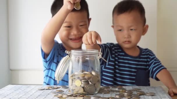 Les Enfants Ralenti Laissent Tomber Argent Pièce Dans Bocal Verre — Video