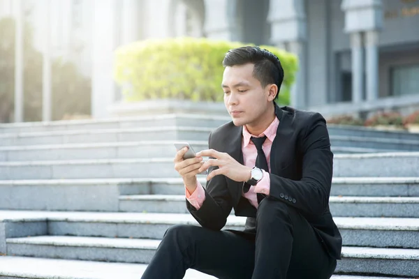 Man op zoek naar mobiele telefoon — Stockfoto