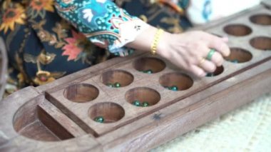 Kadın el congkak, geleneksel Malay iki oyuncu oyun hangi tohum veya mermerler bir tekne şeklinde ahşap tahta oyulmuş depresyoniçine bırakılır oyun.