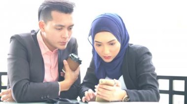 Kafede akıllı telefon kullanan iş adamları.