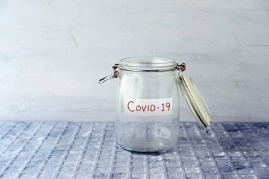 Covid19 etiketli boş cam para kavanozu, finansal konsept.