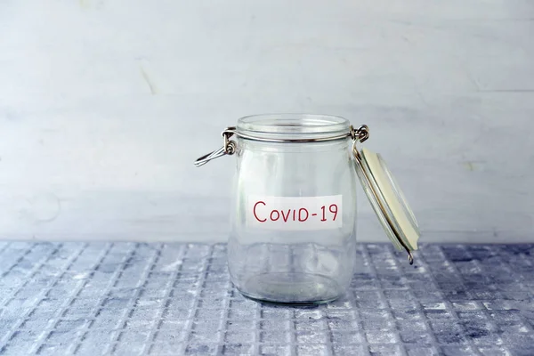 空のガラスのお金瓶とともにCoid19ラベル 金融概念 ストック写真