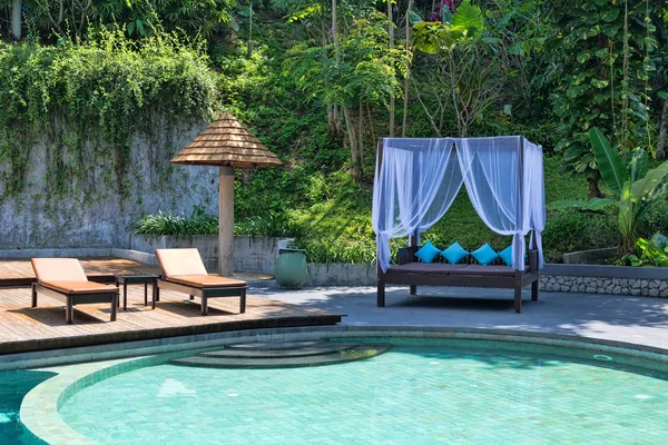 游泳池在棕榈树和阳光不好的绿色 — 图库照片