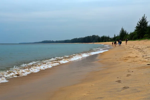 Grupo de personas caminando en una playa tropical — Foto de Stock