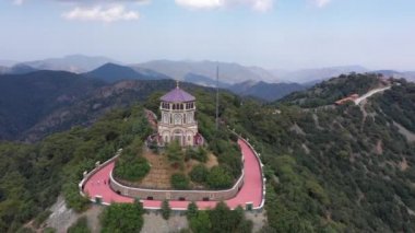 Dağın tepesindeki şapel. Dağlardaki manastır. Dağın tepesindeki orman. İnsansız uçak dağların üzerinden uçuyor. Dağın tepesindeki turistler. Dağın tepesinden geç.
