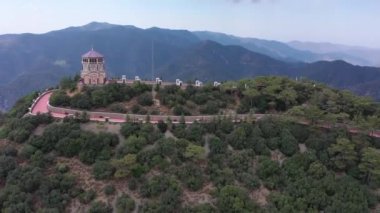 Dağın tepesindeki şapel. Dağlardaki manastır. Dağın tepesindeki orman. İnsansız uçak dağların üzerinden uçuyor. Dağın tepesindeki turistler. Dağın tepesinden geç.
