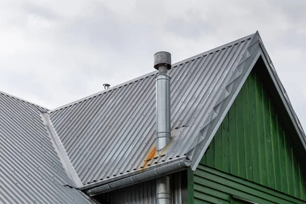 Steel roof of the old house with gutter and ventilation chimneys. — Stock Photo, Image