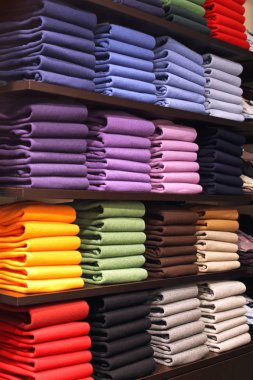 Renkli Pullovers çeşitli raf içinde katlanmış