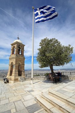 Atina, Yunanistan - 02 Mayıs 2015: Yunan bayrağı zeytin ağacı ve çan kulesinin üst Mount Lycabettus Atina, Yunanistan.
