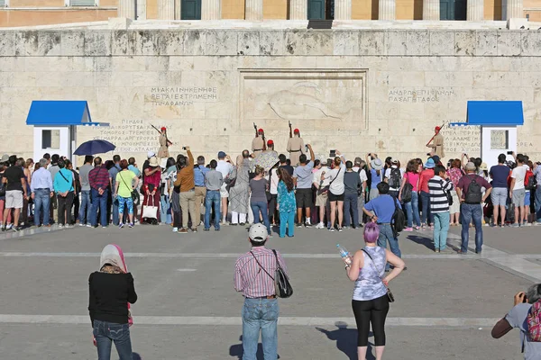 Athens, Yunanistan - 04 Mayıs 2015: Turistler Guard töreni Atina, Yunanistan değiştirme sırasında Yunan Parlamento binası önünde avuç.