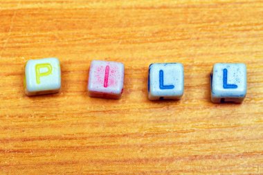 Ahşap arka plan küçük plastik hap harflere