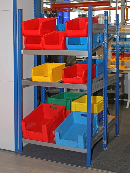 重力货架储存中的五颜六色塑料桶和板条箱 — 图库照片
