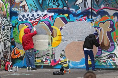 London, Büyük Britanya - 26 Ocak 2013: Londra, İngiltere'de boya ile duvarlar püskürtme iki genç Graffiti sanatçıları Vandallar.