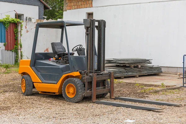 One Orange Forklift Truck Parked in Yard