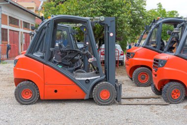 Many Electric Forklift Trucks Parked in Yard clipart