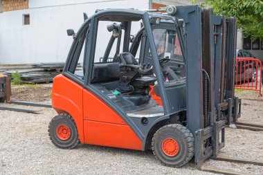 Dışarıda park etmiş bir Kırmızı Forklift var.